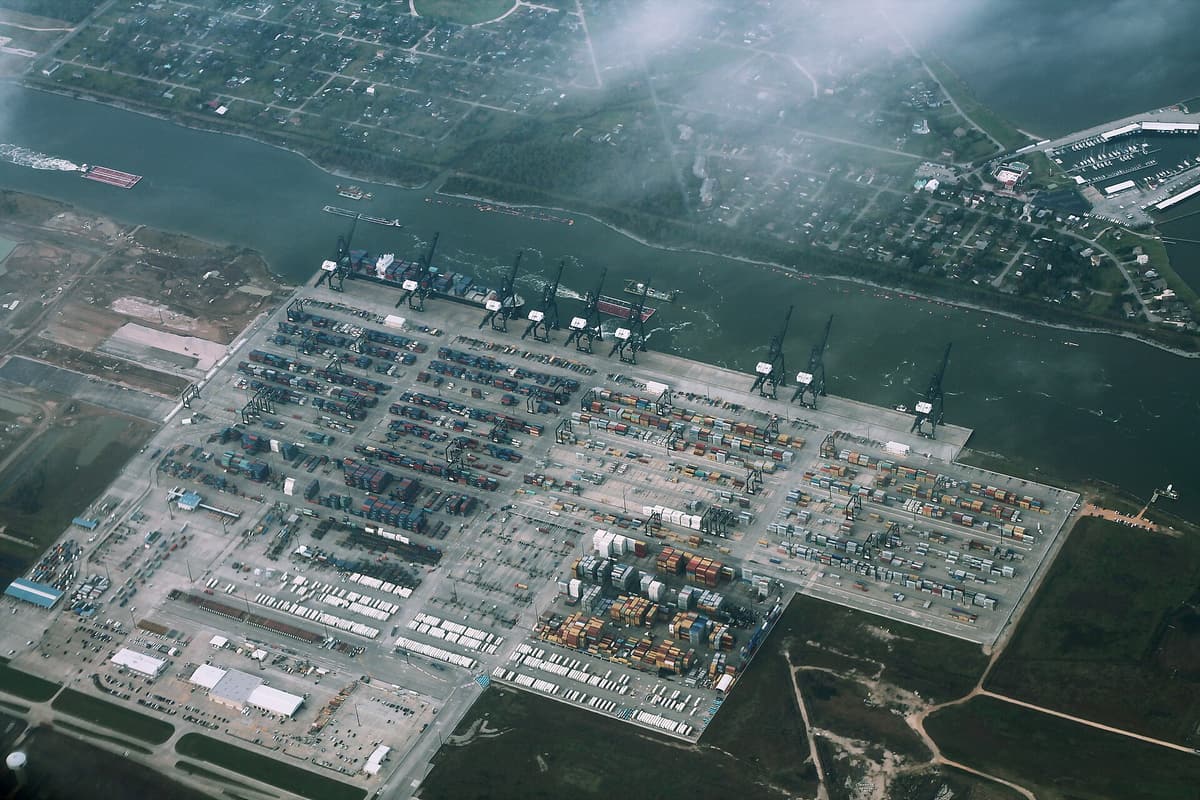 Aerial view of the Bayport Container Terminal near Houston, a large paved yard filled with stacked containers beside a waterway