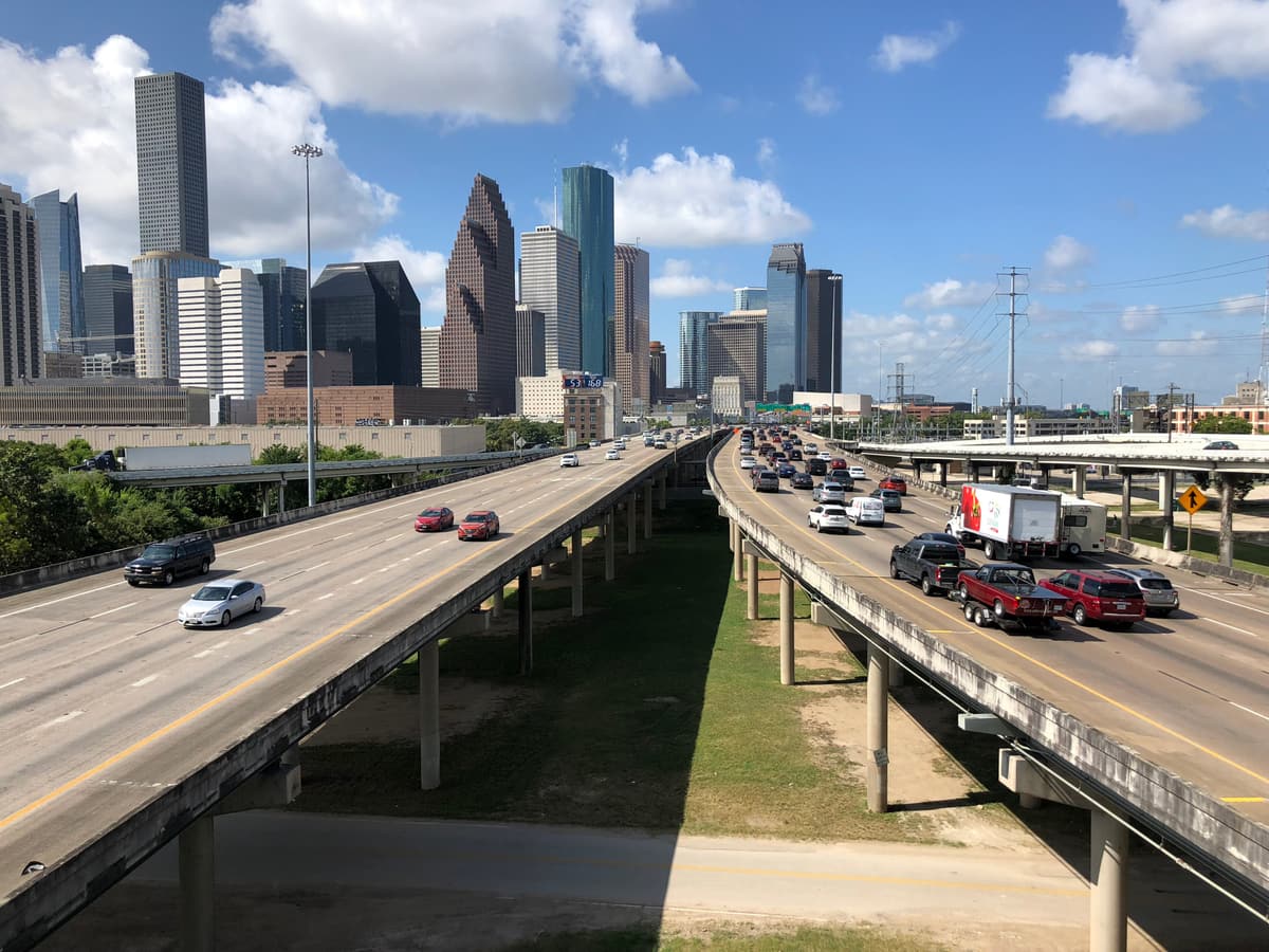 Elevated lanes of Interstate 45 heading south toward the downtown Houston skyline, seen from the connector ramp between westbound I-10 and southbound I-45